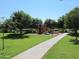 Community playground features swings and other activities with park benches and trees at 3896 E Aragonite Ln, San Tan Valley, AZ 85143