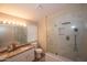 Bright bathroom featuring double sinks with granite counters and an updated glass-enclosed shower at 4032 E Jojoba Rd, Phoenix, AZ 85044