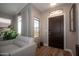 Inviting entryway featuring a dark wood door, neutral walls, and a comfortable chair near a bright window at 4032 E Jojoba Rd, Phoenix, AZ 85044