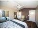 Spacious main bedroom with mirrored closets, a ceiling fan, and a relaxing sitting area at 4032 E Jojoba Rd, Phoenix, AZ 85044