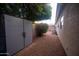 Practical side yard with storage shed, gravel, and mature trees offering privacy and functionality at 4032 E Jojoba Rd, Phoenix, AZ 85044