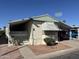 Single-story home featuring a covered driveway, desert landscaping, and a welcoming porch at 4065 E University Dr # 556, Mesa, AZ 85205