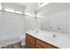 Bathroom with double sinks, wood cabinets, and a bathtub shower combo at 43524 W Bailey Dr, Maricopa, AZ 85138