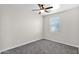 Bedroom featuring gray carpet, a ceiling fan, and a large window at 43524 W Bailey Dr, Maricopa, AZ 85138