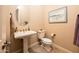 Cozy powder room with pedestal sink, decorative mirror, and charming neutral decor at 4488 N 155Th Ave, Goodyear, AZ 85395