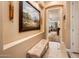 Hallway with tile flooring, a bench, artwork, and a view into the living area at 4488 N 155Th Ave, Goodyear, AZ 85395