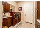 Functional laundry room with stacked washer and dryer, tile flooring, and lots of storage, making chores easier at 4488 N 155Th Ave, Goodyear, AZ 85395