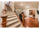 Carpeted staircase with stained wood railing and wrought iron spindles, leading to hardwood floor, offering a warm, inviting atmosphere at 4488 N 155Th Ave, Goodyear, AZ 85395