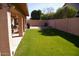 Spacious backyard features a covered patio with tile and green grass, great for entertaining guests at 455 W Gary Ave, Gilbert, AZ 85233