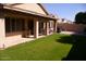 This backyard features an extended covered patio and beautiful green grass at 455 W Gary Ave, Gilbert, AZ 85233