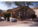 Charming single-story home with an arched entryway and desert landscaping under a mature shade tree at 455 W Gary Ave, Gilbert, AZ 85233