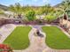 Aerial view of lush backyard with manicured lawn, brick pavers, and mature landscaping at 5137 W Quail Track Dr, Phoenix, AZ 85083