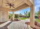 Covered patio with ceiling fan overlooks lush backyard with manicured grass and mature trees at 5137 W Quail Track Dr, Phoenix, AZ 85083