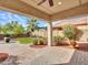 Covered patio with brick pavers overlooks lush backyard with grass, plants, and blue sky at 5137 W Quail Track Dr, Phoenix, AZ 85083