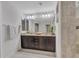 Modern bathroom featuring double sinks, dark wood cabinets, and a tiled shower at 5137 W Quail Track Dr, Phoenix, AZ 85083