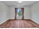 Empty bedroom featuring hardwood floors, a window with patterned drapes, and neutral walls at 5137 W Quail Track Dr, Phoenix, AZ 85083