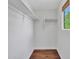 Bright walk-in closet with wood floor, white walls, shelving, and window with natural light at 5137 W Quail Track Dr, Phoenix, AZ 85083