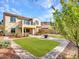 Two-story home with balcony boasts a lush backyard featuring a manicured lawn and brick pavers at 5137 W Quail Track Dr, Phoenix, AZ 85083