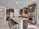 Bright kitchen featuring a granite island with seating, stainless steel appliances, and dark wood cabinetry at 5137 W Quail Track Dr, Phoenix, AZ 85083