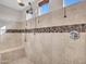 Walk-in shower features custom tile work, a built-in seat, and multiple shower heads at 5137 W Quail Track Dr, Phoenix, AZ 85083