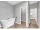 Bright bathroom featuring soaking tub, light wood look flooring, and door to walk-in closet at 514 W Desert Ln, Phoenix, AZ 85041