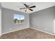 Bedroom featuring neutral paint, carpet, ceiling fan, and natural light from large window at 514 W Desert Ln, Phoenix, AZ 85041