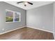 Bedroom featuring a ceiling fan, wood flooring, and a large window for ample natural light at 514 W Desert Ln, Phoenix, AZ 85041