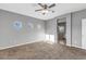 Spacious main bedroom featuring neutral paint, carpet, ceiling fan, and natural light from large window at 514 W Desert Ln, Phoenix, AZ 85041