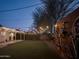 Home's backyard showcasing synthetic grass, ambient string lights, and a bike rack at 6114 N 8Th St, Phoenix, AZ 85014