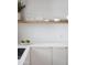 White kitchen counter with modern decor, wooden shelf, and sleek white cabinets at 6114 N 8Th St, Phoenix, AZ 85014