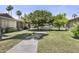 Well-maintained front yard with lush green grass, mature trees and a paved walkway at 6207 N 10Th Way, Phoenix, AZ 85014