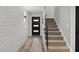 Bright hallway featuring wood floors, leading to an open staircase with modern design elements at 6207 N 10Th Way, Phoenix, AZ 85014