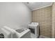 Bright laundry room with brick accent wall, modern machines and patterned tile floor at 6207 N 10Th Way, Phoenix, AZ 85014