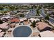 Aerial view of a desert community shows the street and well manicured lawns, as well as desert landscaping at 6450 S Windstream Pl, Chandler, AZ 85249