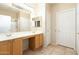 Well-lit bathroom with double sinks, a vanity area, and a separate shower with a glass door at 6450 S Windstream Pl, Chandler, AZ 85249