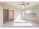 Inviting bedroom with neutral carpet, a ceiling fan, and ample natural light from windows at 6450 S Windstream Pl, Chandler, AZ 85249