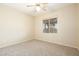 Neutral bedroom with plush carpet, a ceiling fan, and a large window offering natural light at 6450 S Windstream Pl, Chandler, AZ 85249