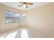 Bright bedroom with neutral carpet, a ceiling fan, and sunlit windows offering peaceful ambiance at 6450 S Windstream Pl, Chandler, AZ 85249