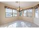 Sunlit dining room with large windows, neutral walls, and a decorative chandelier at 6450 S Windstream Pl, Chandler, AZ 85249