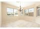 Bright dining area with tile flooring, chandelier, and many windows showcasing the neighborhood at 6450 S Windstream Pl, Chandler, AZ 85249