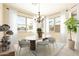 Bright dining area with large windows, elegant chandelier, and modern dining set at 6450 S Windstream Pl, Chandler, AZ 85249