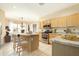 Bright kitchen features an island with bar seating, stainless steel appliances, and granite countertops at 6450 S Windstream Pl, Chandler, AZ 85249