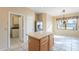 View of kitchen island, stainless fridge, and laundry room access, ideal for modern living at 6450 S Windstream Pl, Chandler, AZ 85249