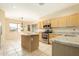 Well-lit kitchen with tiled floors and island, ideal for cooking and entertaining at 6450 S Windstream Pl, Chandler, AZ 85249