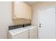 Functional laundry area with overhead cabinets and access door to the exterior at 6450 S Windstream Pl, Chandler, AZ 85249