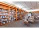 Warm and inviting library with floor-to-ceiling bookshelves and comfortable seating areas at 6450 S Windstream Pl, Chandler, AZ 85249