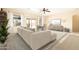 Bright living room with large windows, neutral tones, ceiling fan, and inviting furniture arrangement at 6450 S Windstream Pl, Chandler, AZ 85249