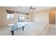 Bright living room with tile and carpet, a ceiling fan, and a glass coffee table at 6450 S Windstream Pl, Chandler, AZ 85249