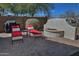 Inviting backyard patio featuring a built-in firepit and comfortable lounge chairs at 6614 W Victory N Way, Florence, AZ 85132