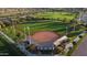 Aerial view of a well-maintained baseball field with green grass, lights, and a covered dugout area at 6614 W Victory N Way, Florence, AZ 85132